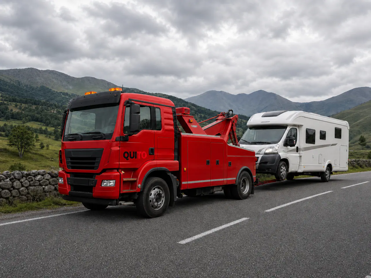 Quito-branded red European recovery vehicle assisting a motorhome on a scenic Georgian regional road